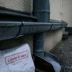 Gouttiere sur mur en limite de propriété, sans debord, zinc fonce et descente raccordee